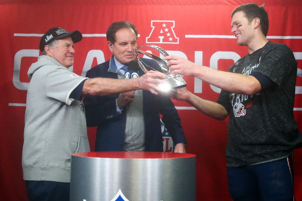 New England Patriots’ head coach Bill Belichick hands the trophy to quarterback Tom Brady after their win over the Kansas City Chiefs in the AFC Championship game at Arrowhead Stadium in Kansas City Sunday. — Reuters