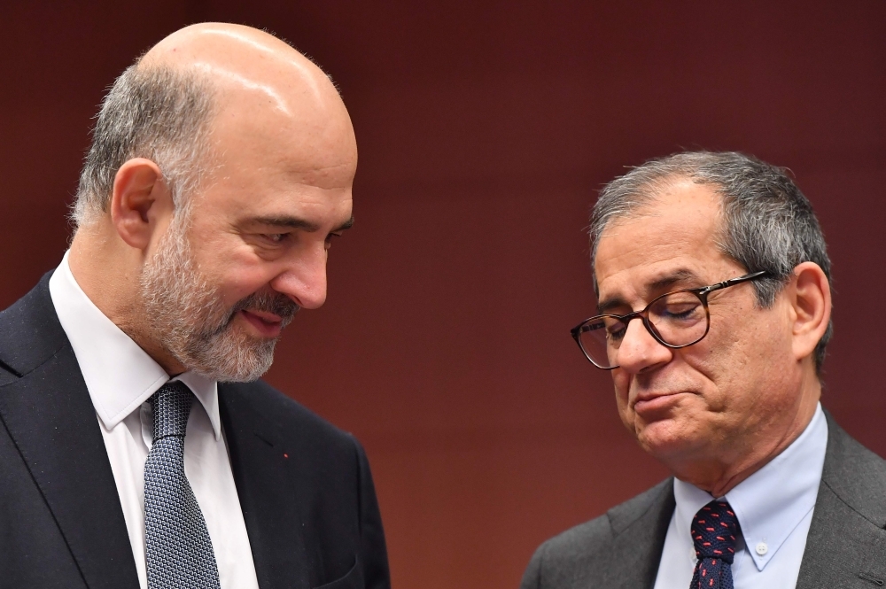 European Commissioner for Economic and Financial Affairs, Taxation and Customs Pierre Moscovici, left, and Italy’s Finance Minister Giovanni Tria, right, talk during a Eurogroup meeting at the European Council in Brussels on Monday. — AFP