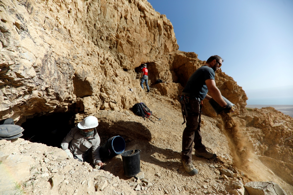 Volunteers and archeologists work at a dig near caves in the Qumran area in the Israeli-occupied West Bank. 