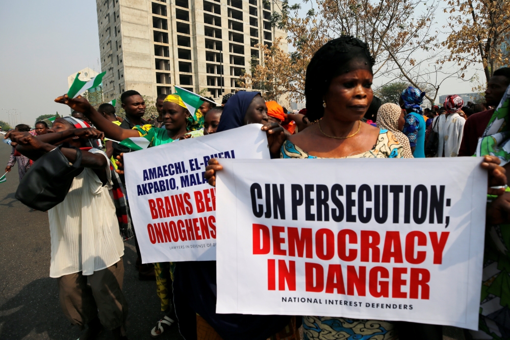 People hold banners during a protest over the suspension of the chief justice of Nigeria (CJN), Walter Onnoghen, in Abuja, Nigeria on Monday. — Reuters