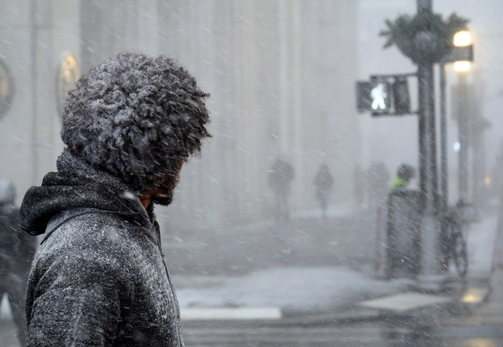 A man waits to cross a street during heavy snow fall in downtown Manhattan on Thursday in New York City. Bitter cold with temperatures lower than Antarctica gripped the American Midwest on Wednesday, grounding flights, closing schools and businesses and raising frostbite and hypothermia fears for homeless residents. — AFP