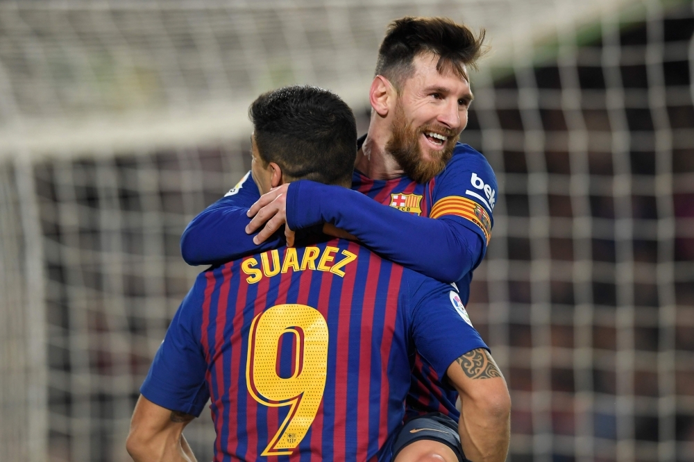 Barcelona's Argentinian forward Lionel Messi celebrates with Barcelona's Uruguayan forward Luis Suarez after scoring during the Spanish Copa del Rey (King's Cup) quarterfinal second leg football match against Sevilla at the Camp Nou Stadium in Barcelona on Wednesday. — AFP