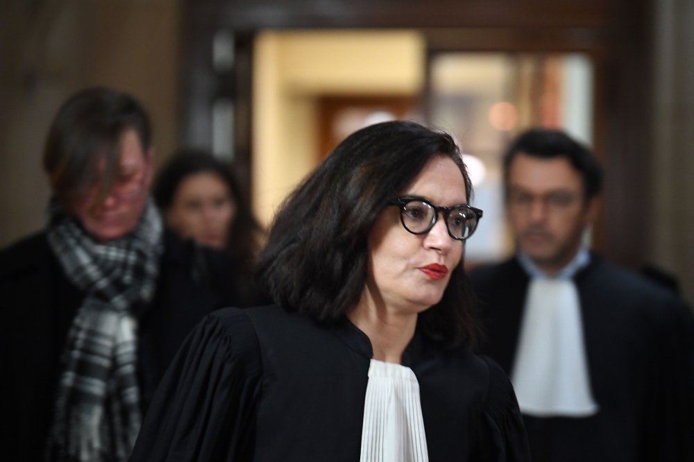 (FILES) In this file photo taken on January 14, 2019 Sophie Obadia (C), the lawyer of Canadian national Emily Spanton (back L), arrives with her client for a hearing at the Criminal Court (Cour d'Assises) in Paris. French policemen Antoine Quirin and Nicolas Redouane have been on January 31, 2019 sentenced to 7 years in prison for raping Emily Spanton in Paris criminal investigation department headquarters, then located at the 36 Quai des Orfevres, after meeting her in a pub. / AFP / Eric FEFERBERG
