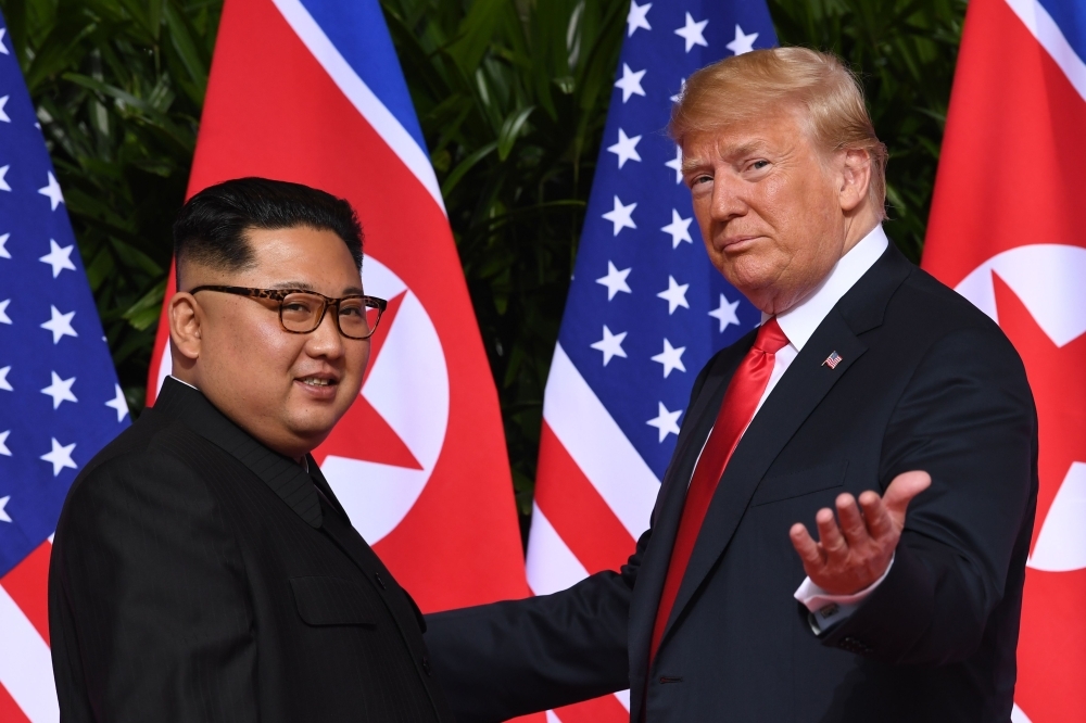 US President Donald Trump, right, meets with North Korea’s leader Kim Jong Un, left, at the start of their US-North Korea summit at the Capella Hotel on Sentosa Island in Singapore in this June 12, 2018 file photo. — AFP
