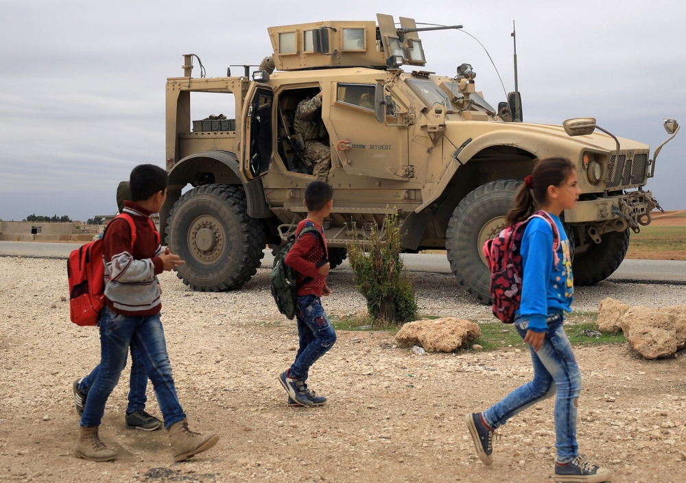 Syrian schoolchildren walk as US troops patrol near Turkish border in Hasakah, Syria, in this Nov. 4, 2018 file photo. — Reuters