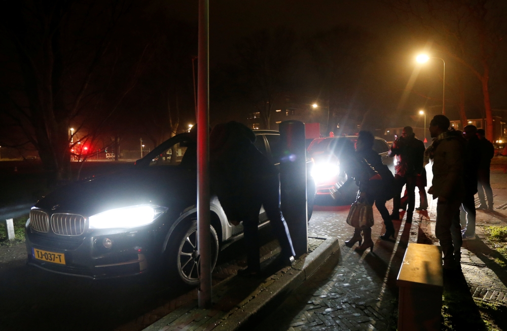 Supporters of former Ivory Coast President Laurent Gbagbo and arriving cars are seen outside a prison in The Hague, the Netherlands, on Friday. — Reuters