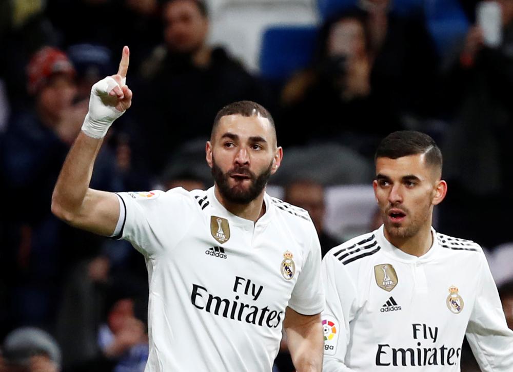 Real Madrid’s Karim Benzema celebrates scoring their first goal with Dani Ceballos during their Spanish League match against Deportivo Alaves at Santiago Bernabeu in Madrid Sunday. — Reuters