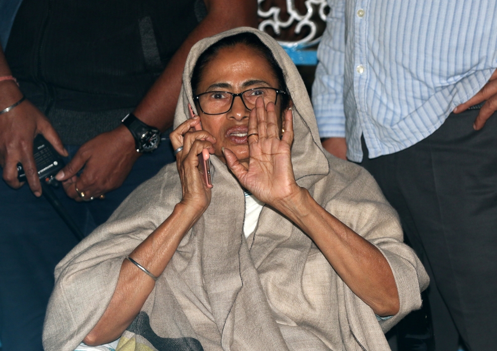 Mamata Banerjee, Chief Minister of the state of West Bengal, speaks on her mobile phone as she sits in a protest against an attempted raid by India's Central Bureau of Investigation (CBI) officials on the residence of Kolkata police commissioner, in Kolkata, India, on Sunday. — Reuters
