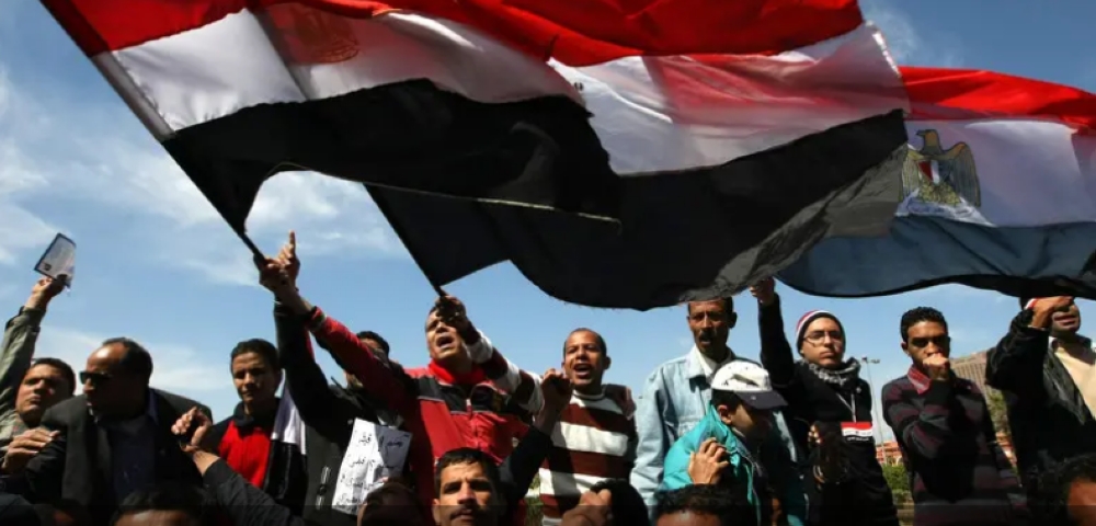Protesters wave Egyptian flags at Cairo’s Tahrir Square as hundreds demonstrate against sectarianism. — Archives