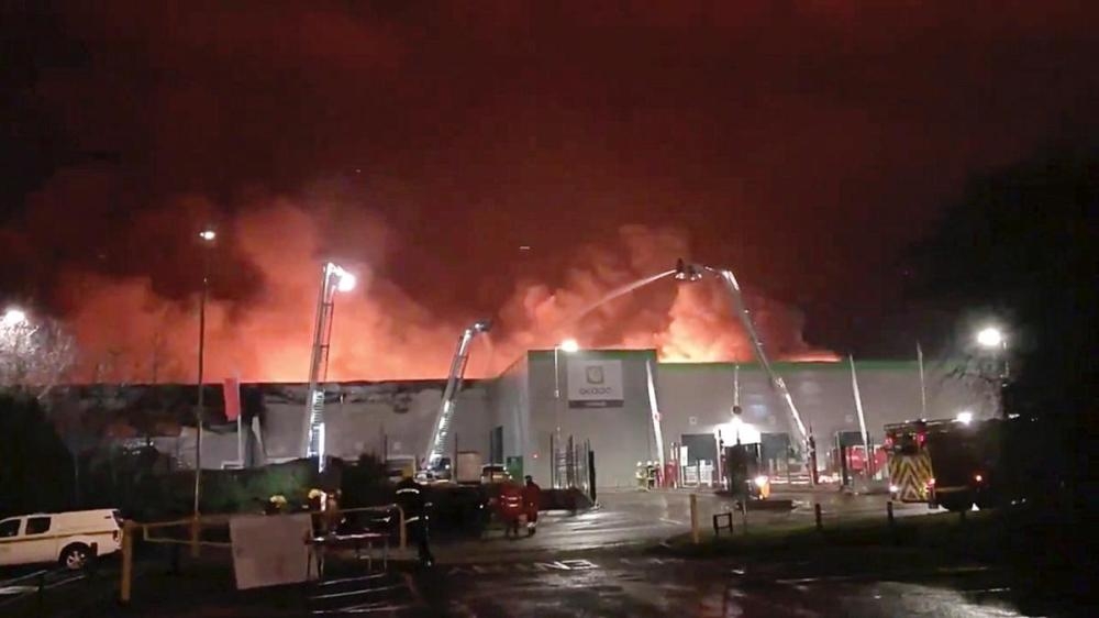 Firefighters work at the scene of the Ocado's flagship robotic distribution centre in flames in Andover, Britain Tuesday in this still picture. — Reuters