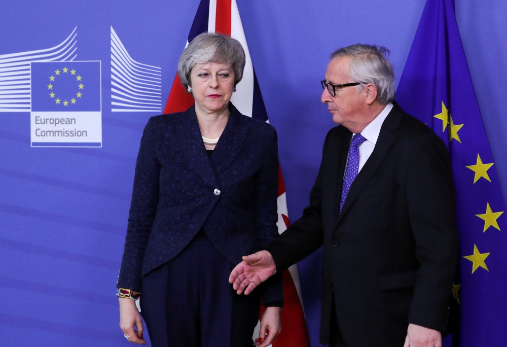 European Commission President Jean-Claude Juncker shakes hands with British Prime Minister Theresa May at the European Commission headquarters in Brussels, Belgium, on Thursday. — Reuters