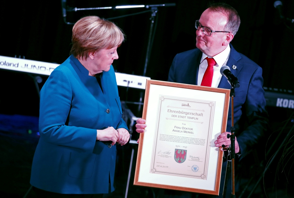German Chancellor Angela Merkel receives honorary citizenship in her home town Templin from Templin mayor Detlef Tabbert, in Templin, Germany, on Friday. — Reuters