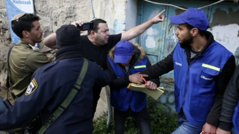 Members of the Israeli security forces intervene as a Jewish settler (center) shouts at members of the Palestinian Youth Against Settlements (YAS) activists in the occupied West Bank town of Hebron, Sunday. — AFP