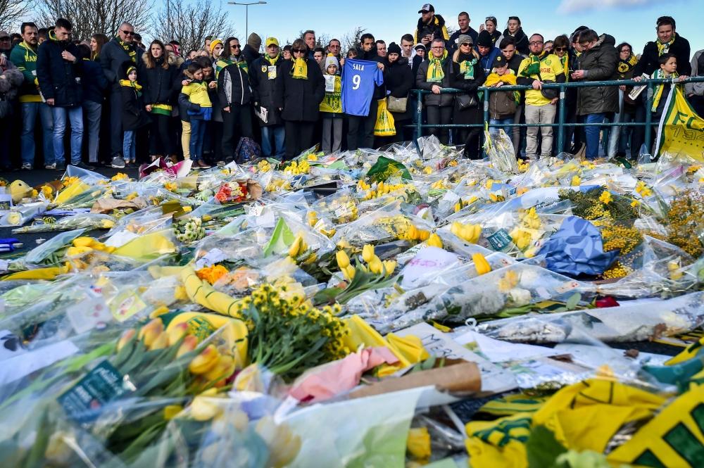 Nantes supporters gather to pay tribute to late Argentinian forward Emiliano Sala prior to the French L1 football match between FC Nantes and Nimes Olympique at the La Beaujoire Stadium in Nantes. Nantes FC announced that it will freeze the No. 9 jersey as a tribute to Cardiff City and former Nantes footballer Emiliano Sala who died in a plane crash in the English Channel on January 21, 2019. — AFP 