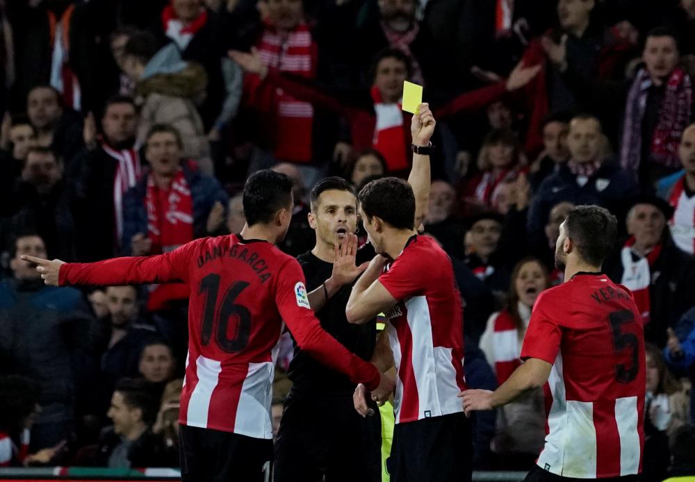 Athletic Bilbao’s Oscar de Marcos is shown a yellow card by referee Carlos del Cerro during their Spanish league match against Barcelona at San Mames, Bilbao, Sunday. — Reuters