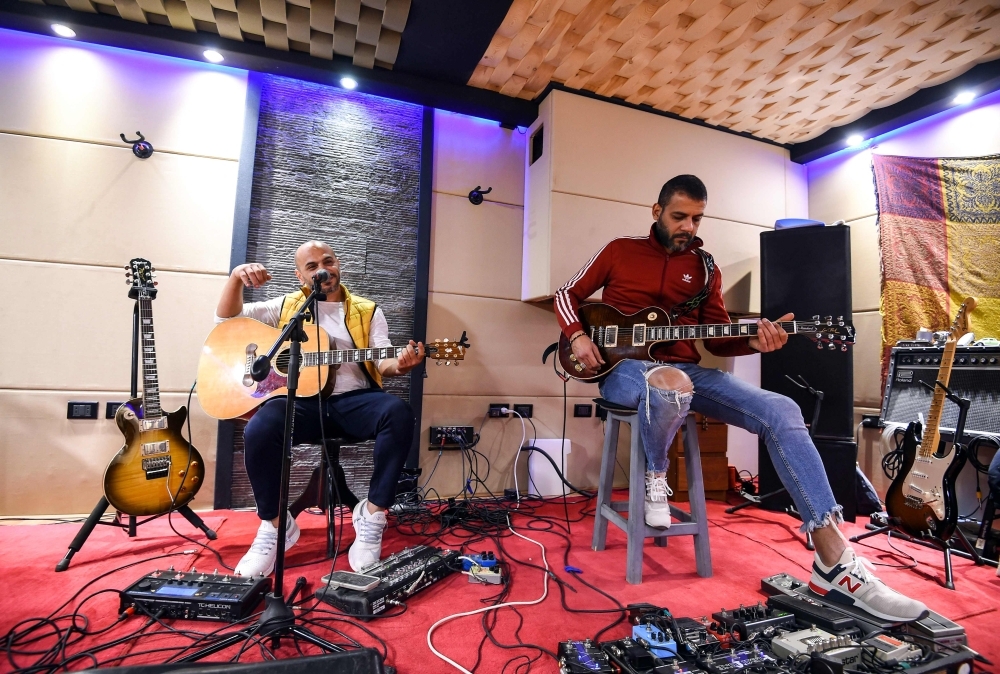 


Hani El Dakkak (left), lead singer and guitarist, and Mahmoud Siam, guitarist for Egyptian rock band Massar Egbari, warm up in a recording studio in the Egyptian capital Cairo. — AFP