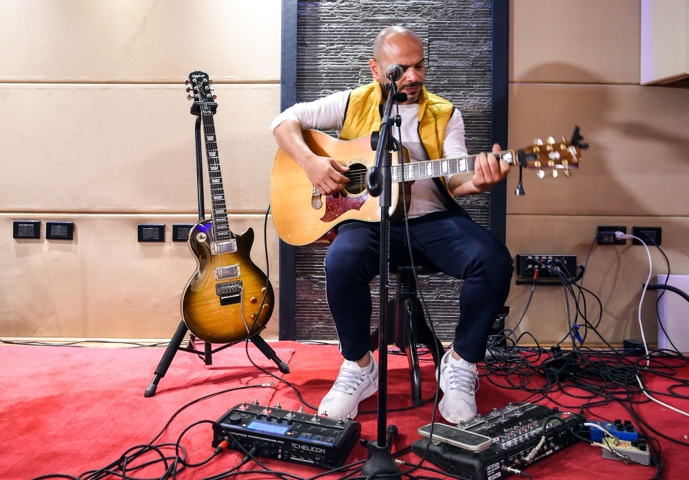 


Hani El Dakkak (left), lead singer and guitarist, and Mahmoud Siam, guitarist for Egyptian rock band Massar Egbari, warm up in a recording studio in the Egyptian capital Cairo. — AFP