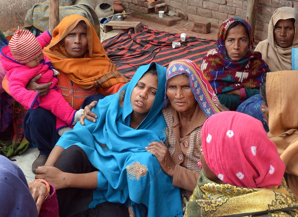A woman is consoled after her husband’s death from bootleg alcohol in Saharanpur, northern state of Uttar Pradesh, India Monday. — Reuters