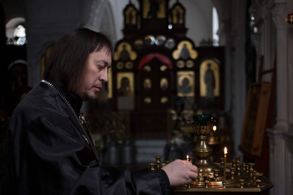 Russian Orthodox priest Konstantin Volkov, who participated in the Soviet military campaign in Afghanistan, places a candle at a church in a village outside Moscow in this Jan. 28, 2019 file photo. — AFP