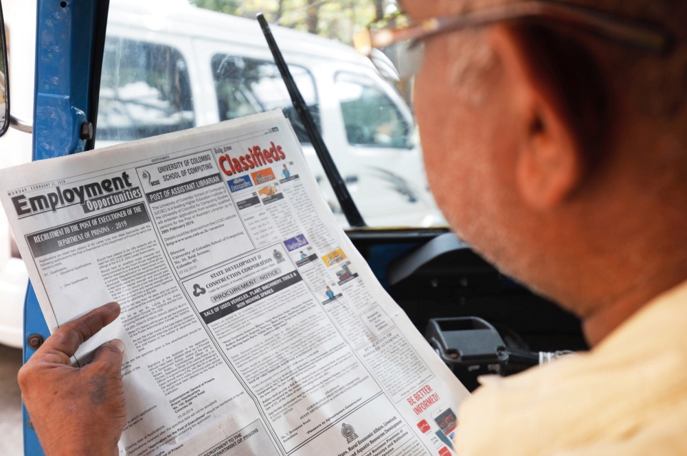 A man reads an advertisement of the vacancy for hangmen on a newspaper in Colombo, Sri Lanka, on Tuesday. — Reuters