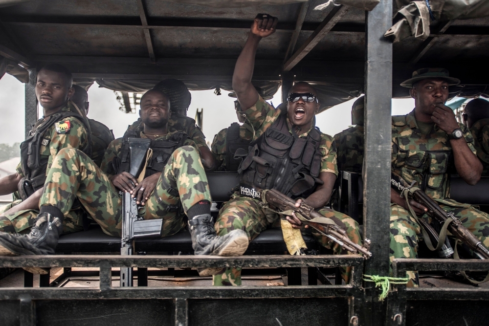 Nigerian soldiers ride in a truck during a patrol of Aba, a city in southern eastern Nigeria and a stronghold for pro-biafran separatists, during a military patrol on Friday, one day ahead Nigerian elections. — AFP