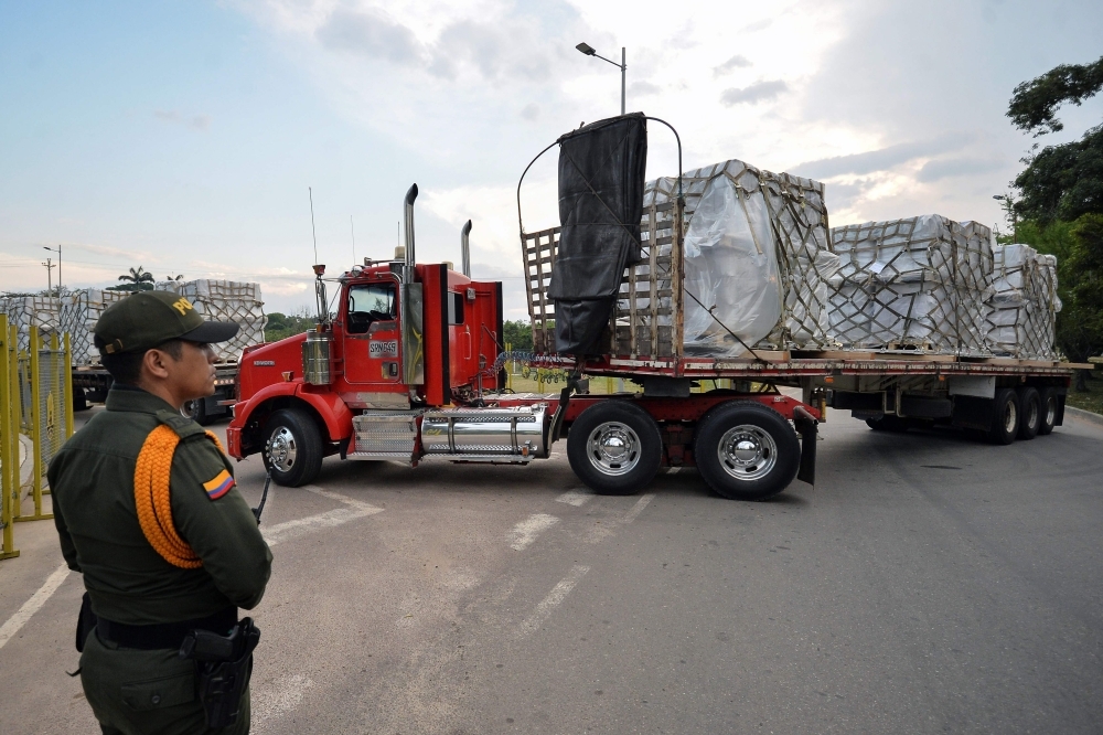 Trucks loaded with humanitarian aid for Venezuela drive toward the Tienditas Bridge in Cucuta, Colombia, on the border with Tachira, Venezuela, on sunday.  Venezuelan opposition leader Juan Guaido on Saturday called for nationwide protests next week to support volunteers planning to travel to the border with Colombia to bring in US humanitarian aid, the latest flashpoint in the country's political crisis.  — AFP