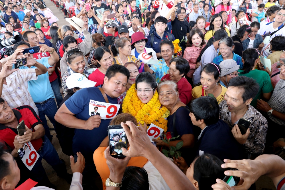 Sudarat Keyuraphan, center, Pheu Thai Party and Prime Minister candidate poses for a photo with her supporters during an election campaign in Ubon Ratchathani Province, Thailand, on Monday. — Reuters
