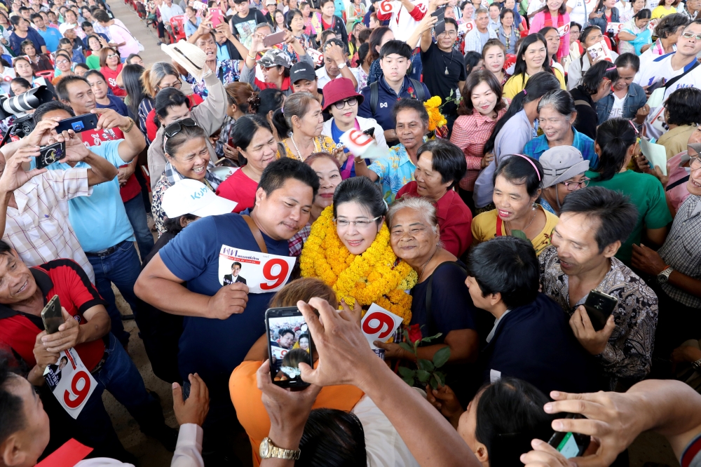 Sudarat Keyuraphan, center, Pheu Thai Party and Prime Minister candidate poses for a photo with her supporters during an election campaign in Ubon Ratchathani Province, Thailand, on Monday. — Reuters