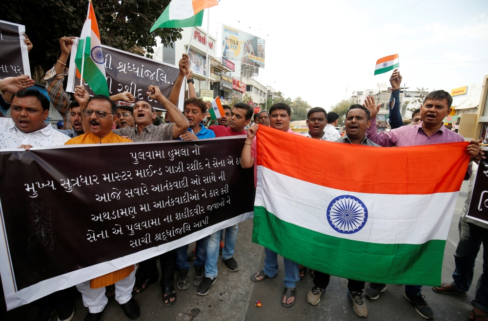 Demonstrators hold an Indian flag as they shout slogans during a protest against the attack on a bus that killed members of the Central Reserve Police Force (CRPF) personnel in south Kashmir last week, in Ahmedabad, India, on Monday. — Reuters