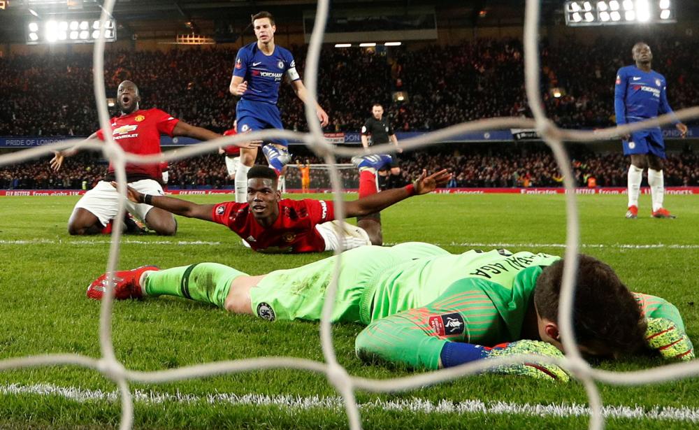 Manchester United’s Paul Pogba celebrates scoring their second goal with Romelu Lukaku as Chelsea’s Kepa Arrizabalaga looks dejected during their FA Cup fifth round match against Chelsea at Stamford Bridge, London, Monday. — Reuters