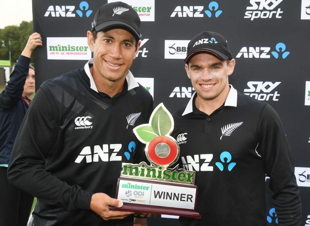 Ross Taylor (L) holds trophy.