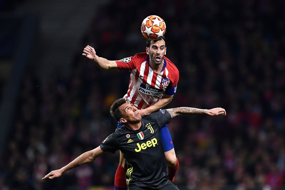 Atletico Madrid's Uruguayan defender Diego Godin (back) heads the ball over Juventus' Croatian forward Mario Mandzukic during the UEFA Champions League round of 16 first leg football match between Club Atletico de Madrid and Juventus FC at the Wanda Metropolitan stadium in Madrid on Wednesday. — AFP