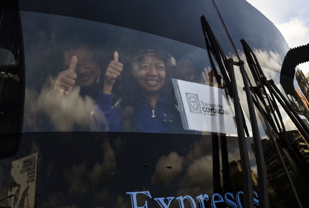 Opposition deputies wave while traveling in a caravan of buses heading to the border with Colombia to bring in US-supplied humanitarian aid, in Caracas on Thursday. — AFP