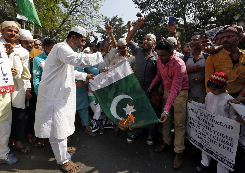 Muslims burn a Pakistani flag during a protest against the attack on a bus that killed 40 Central Reserve Police Force (CRPF) personnel in south Kashmir last week, outside a mosque in Kolkata, India, on Friday. — Reuters
