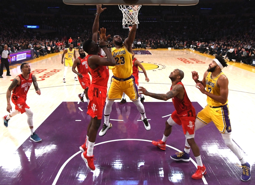 LeBron James No. 23 of the Los Angeles Lakers scores in front of Clint Capela No. 15 of the Houston Rockets as JaVale McGee No. 7 and PJ Tucker No. 17 look on during a 111-106 Lakers win at Staples Center on Thursday in Los Angeles, California. — AFP