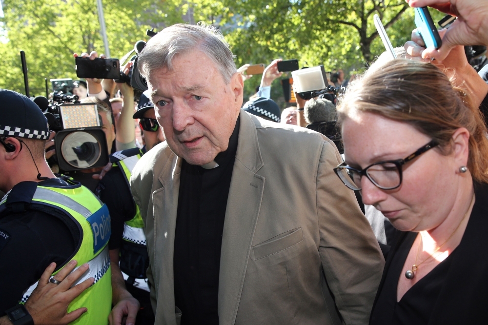 Cardinal George Pell, center, makes his way to the court in Melbourne on Wednesday. — AFP