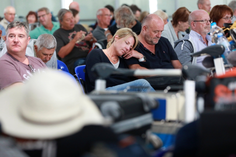 Passengers pass their time after Thai Airway canceled all the flights to and from Europe at Suvarnabhumi Airport in Bangkok, Thailand, on Thursday. — Reuters