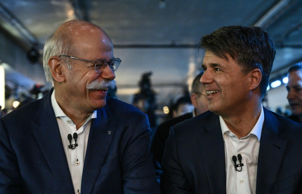 The CEO of German auto giant Daimler AG Dieter Zetsche (L) and CEO of German carmaker BMW Harald Krueger sit side by side during the presentation of the merger of their car sharing activities in Berlin. German high-end car giants BMW and Mercedes-Benz maker Daimler said on Thursday they would work together to develop automated driving and driver assistance systems, the latest cooperation for the historically fierce rivals. — AFP