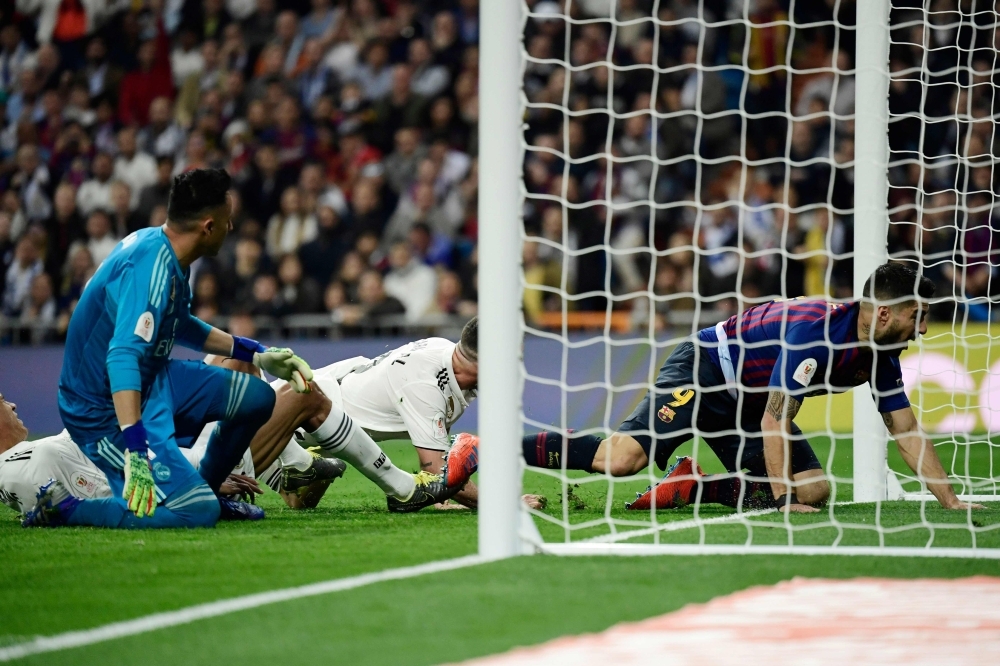 Barcelona's Uruguayan forward Luis Suarez (R) scores his second goal during the Spanish Copa del Rey (King's Cup) semifinal second leg football match between Real Madrid and Barcelona at the Santiago Bernabeu Stadium in Madrid on Wednesday. — AFP