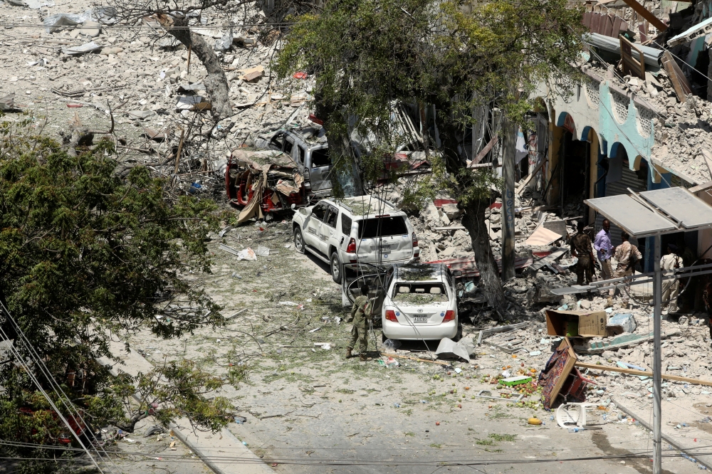 Security personnel are seen next to buildings damaged at the scene where a suicide car bomb exploded targeting a Mogadishu hotel in a business center in Maka Al Mukaram street in Mogadishu, Somalia, on Friday. — Reuters
