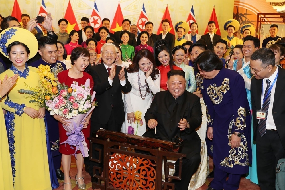 North Korea's leader Kim Jong Un (3rd R) plays Dan Bau, a traditional Vietnamese musical instrument, as Vietnam's President Nguyen Phu Trong (center) applauds during a banquet in Hanoi. — AFP