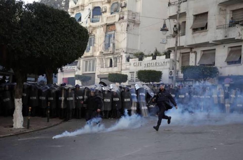 Protesters clash with police in Algiers on Friday. — AFP