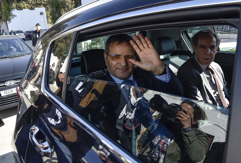 Retired Algerian army general Ali Ghediri (center) waves from his car as he arrives to submit his candidacy before the constitutional council for the upcoming presidential election, on Sunday. — AFP