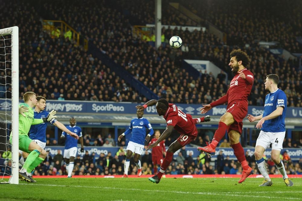 Liverpool's striker Sadio Mane (C) and Mohamed Salah fail to connect a ball during the English Premier League football match against Everton at Goodison Park in Liverpool Sunday. — AFP