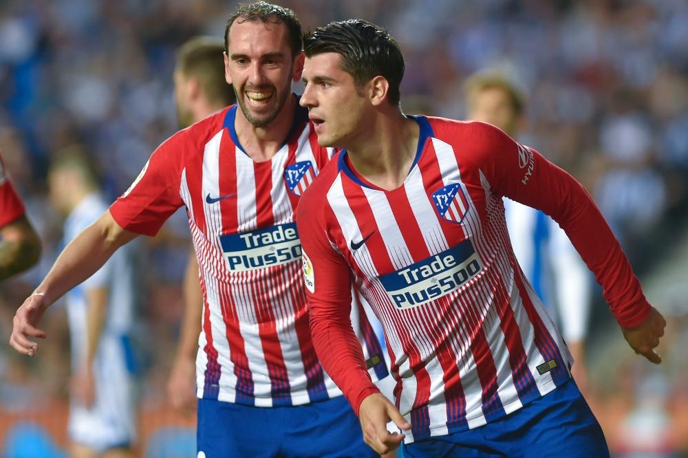 Atletico Madrid’s Alvaro Morata celebrates with Diego Godin (L) after scoring a goal during the Spanish league football match against Real Sociedad at the Anoeta Stadium in San Sebastian Sunday. — AFP