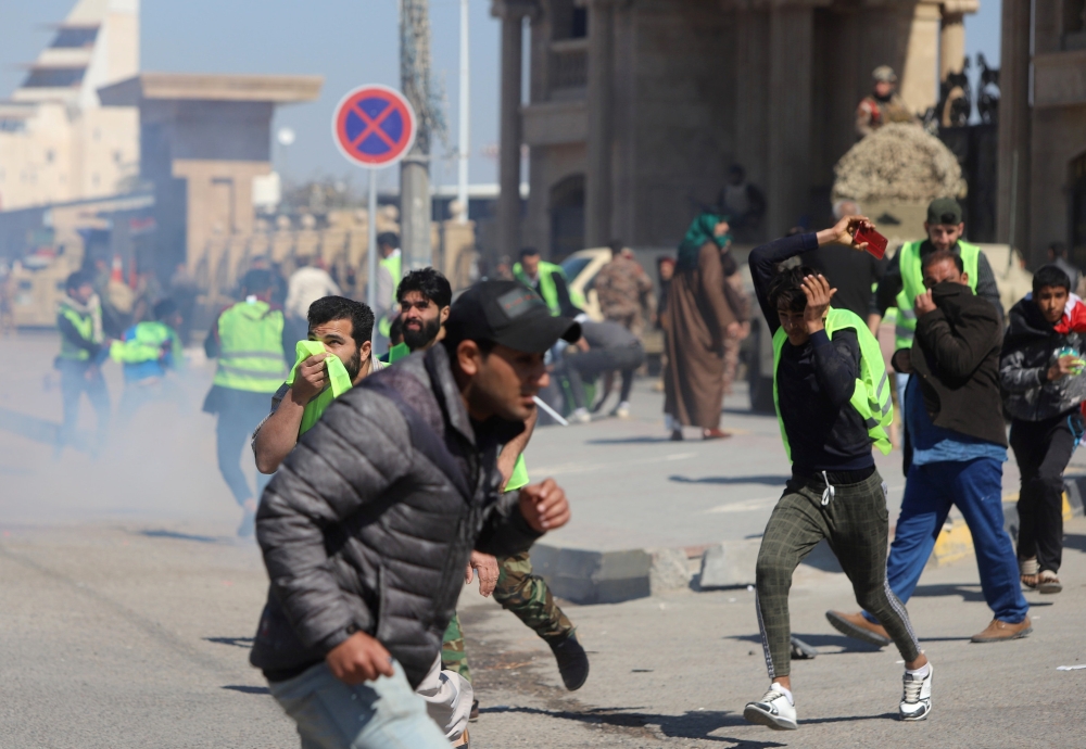 Demonstrators disperse as Iraqi security forces use tear gas during a protest in front of the governorate building in Basra, Iraq, on Thursday. — Reuters