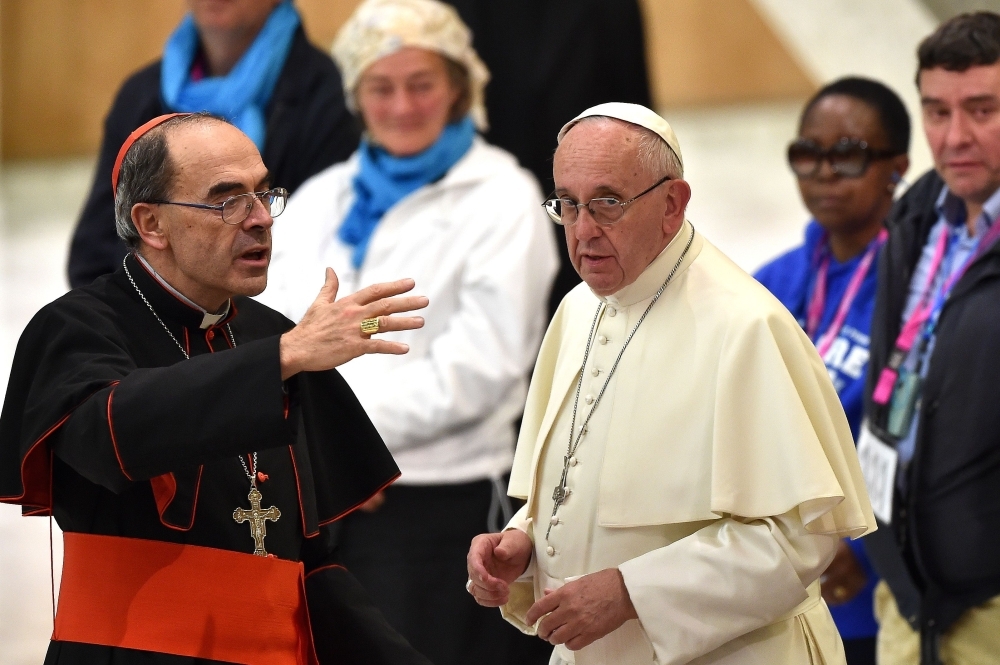 Pope Francis, right, listens to French Cardinal Philippe Barbarin, left, during an audience with homeless and socially excluded people in the Paul-VI hall at the Vatican in this Nov. 11, 2016 file photo. — AFP