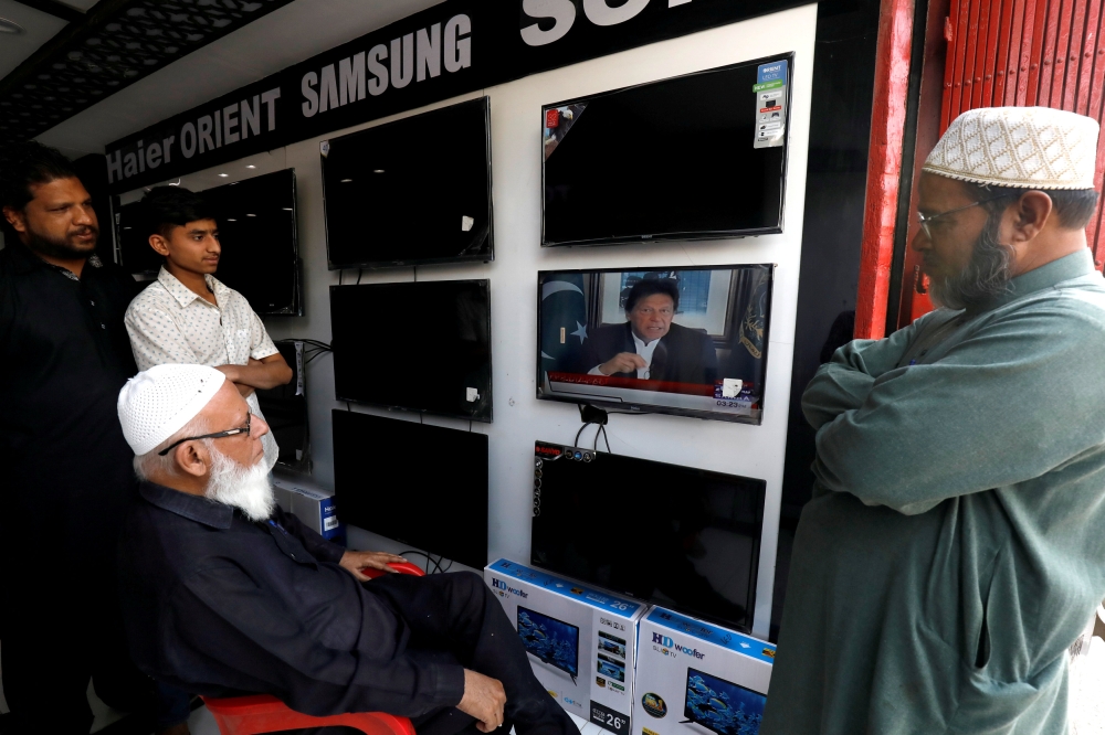 Shopkeepers watch the speech of Pakistani Prime Minister Imran Khan after Pakistan shot down two Indian military aircraft, at a shop selling television screens in Karachi, Pakistan, in this Feb. 27, 2019 file photo. — Reuters