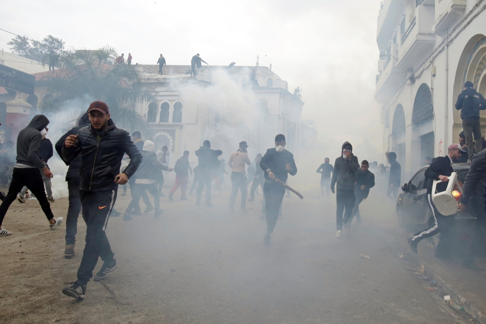 People clash with anti-riot police during the protest against President Abdelaziz Bouteflika in Algiers, Algeria, on Friday. — Reuters