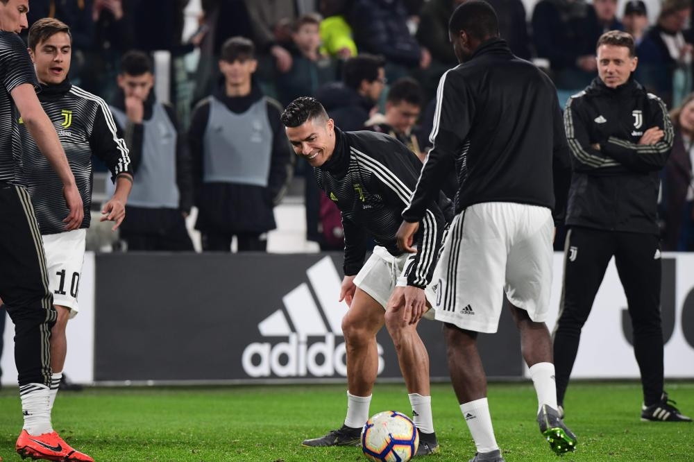 Juventus' Portuguese forward Cristiano Ronaldo (C) jokes as he warms up with teammates  prior to the Italian Serie A football match Juventus vs Udinese on March 8, 2019 at the Juventus Allianz stadium in Turin. / AFP / Miguel MEDINA
